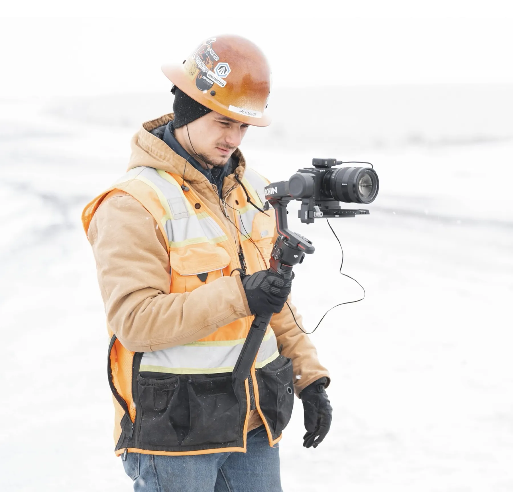 Jack filming with a gimbal on a snowy job site